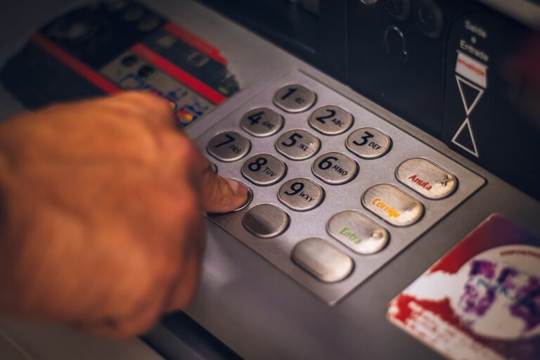 Hand entering a PIN on a bank terminal, representing strong customer authentication under PSD2